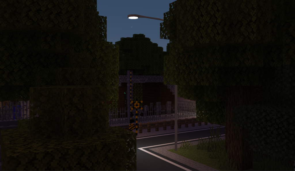 車道用の大きな街灯が、踏切のある十字路を照らしている。